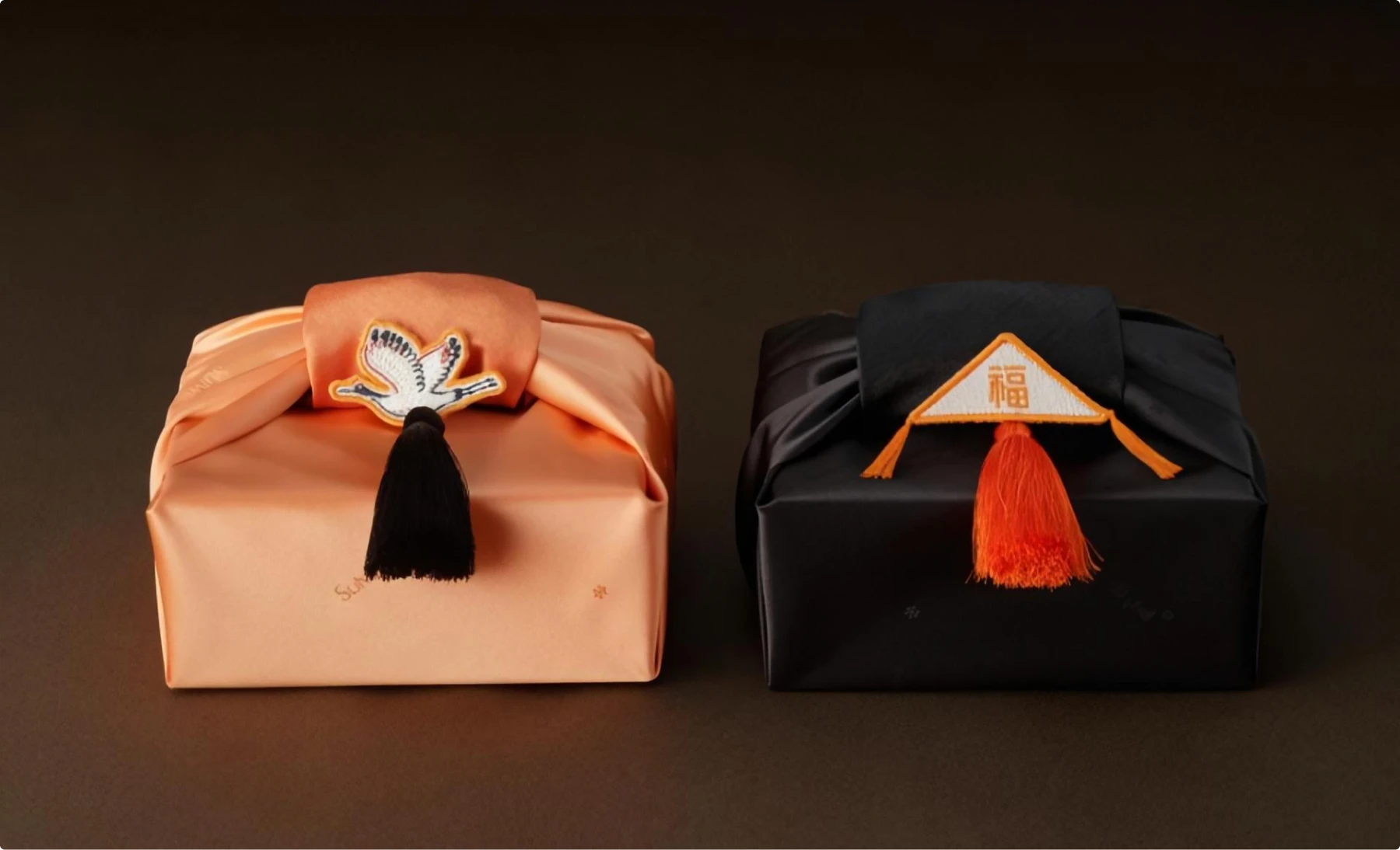 Two elegant gift boxes in coral and black with ornate Korean traditional designs, featuring decorative tassels and ceremonial wrapping that transforms premium skincare into ritual-worthy experiences