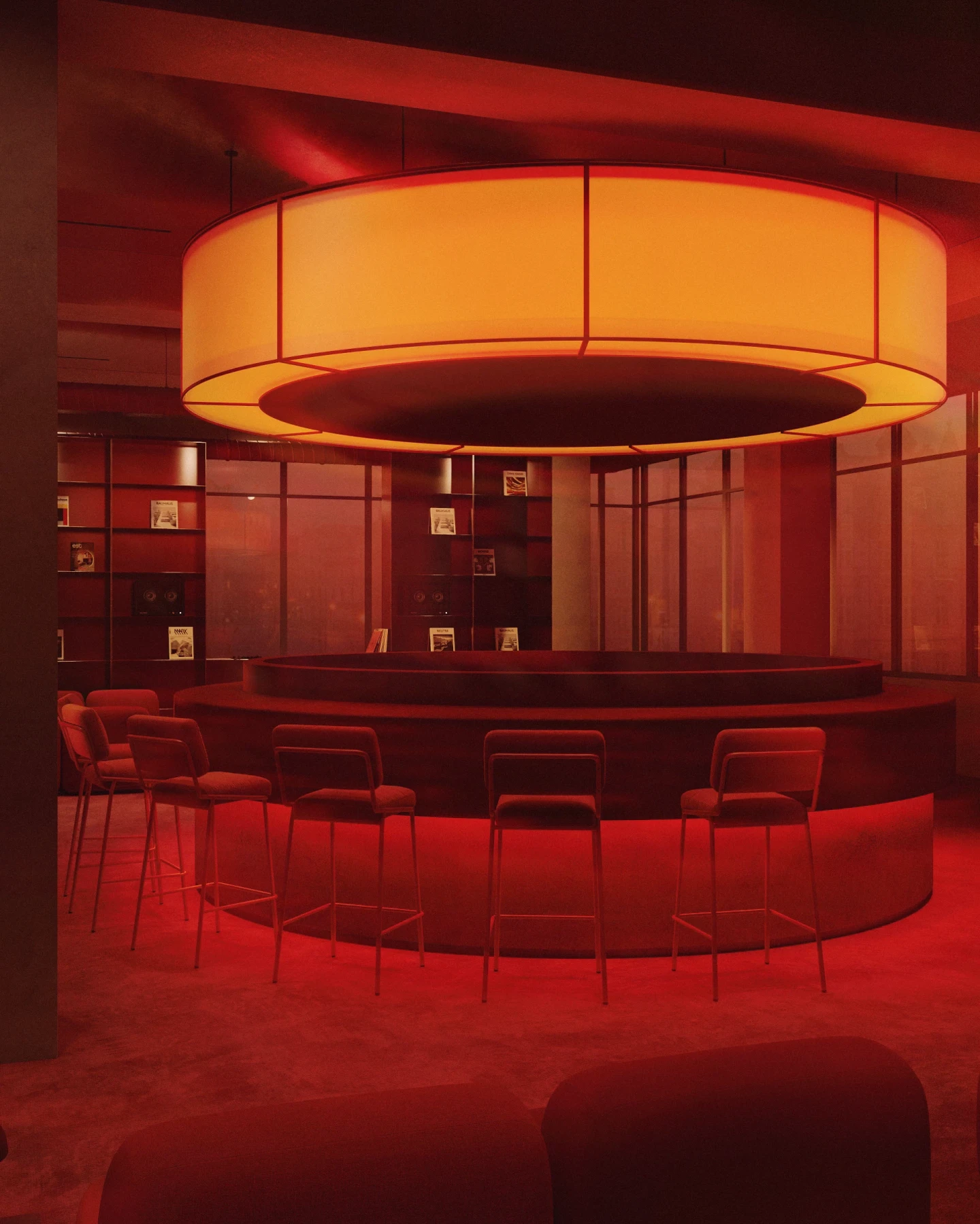 Dim red bar interior centered on a circular island bar with high stools and a large glowing orange ring pendant light, surrounded by red shelves and floor-to-ceiling windows